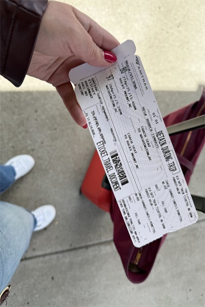 Picture of a woman holding an Amtrak ticket for passage to Washington D.C. from Rocky Mount, North Carolina
