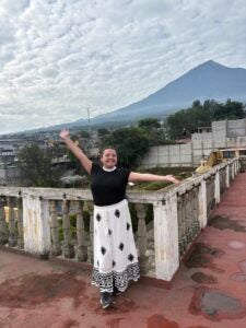 Stephanie standing in front of a mountain in the horizon with her arms outstretched.