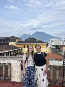 Stephanie and another student standing in front of a mountainous horizon.