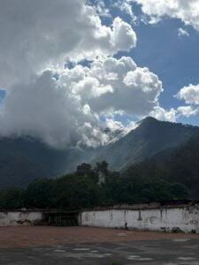 Mountainous horizon with billowing clouds in the sky.
