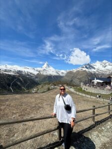Natalia leaning on a wooden fence with the Matterhorn in the background.