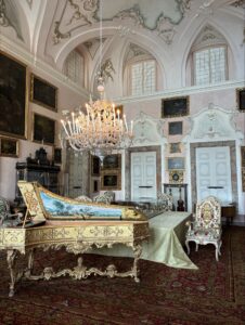 An ornate chandelier lit above a decorative piano.