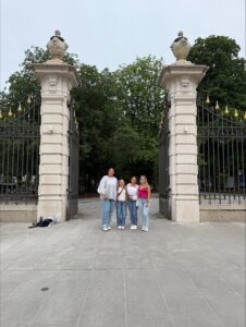 Natalia and three other students standing between two large pillars of a gate.